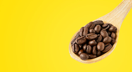Close-up of roasted coffee beans on a wooden spoon, placed on a wooden background, perfect for coffee-related designs and concepts.