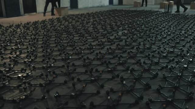 Young people lay out fpv drones and quadcopters on the floor.