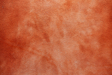 Painted wall with rusty red texture, showcasing an aged appearance.