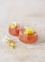 Refreshing beverage with flowers and fruit served in elegant glassware on a rustic table setting