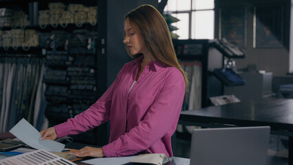 Female fashion designer woman girl dressmaker artist stylist tailor choosing fabric material samples creative design studio atelier Caucasian businesswoman customer buyer choose cloth textile shop buy