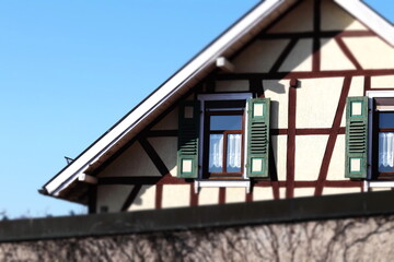 Fragment von einem Fachwerkhaus gegen blauen Himmel.