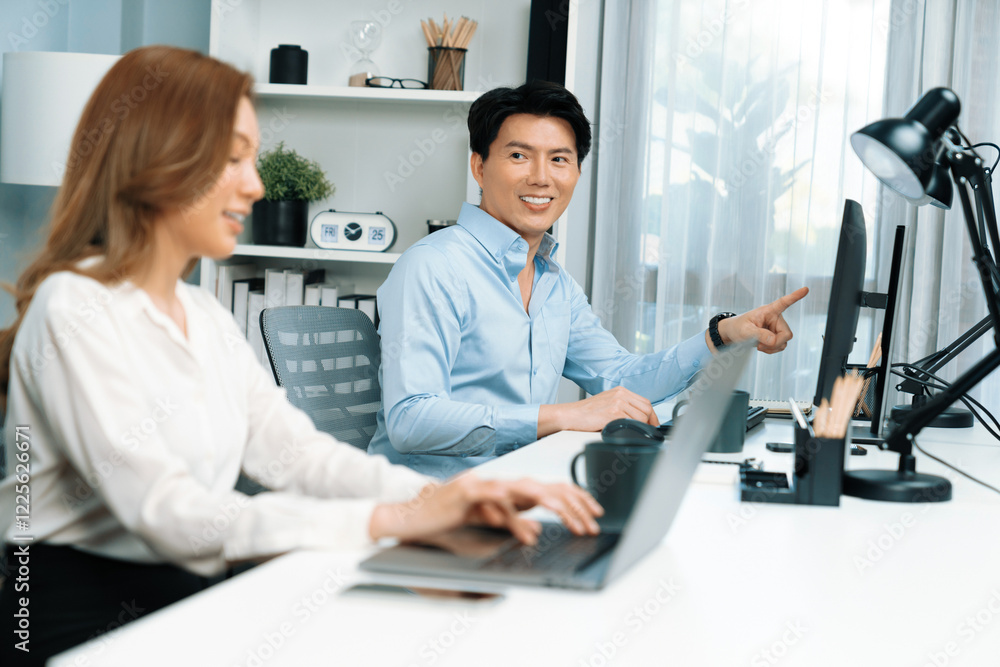 Poster smiling asian man talking with woman colleague in planning marketing report project on laptop casual