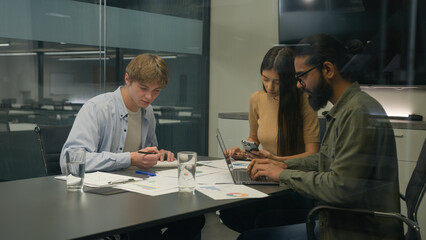 Multiracial colleagues corporate teamwork diverse coworkers businessmen businesswoman partnership at office boardroom Arabian men Caucasian woman business project write paperwork laptop phone devices