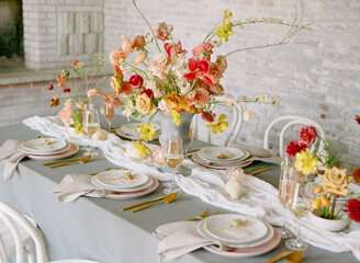 Stunning floral centerpiece decorates an elegant dining table for a special gathering in a cozy...