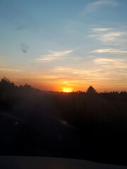 Stunning sunset view over a forest landscape with colorful sky and distant horizon