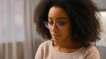 Close up female African American woman wearing glasses eyeglasses vision problem medicine eyesight businesswoman working at home looking at laptop screen pc computer monitor reflection in spectacles