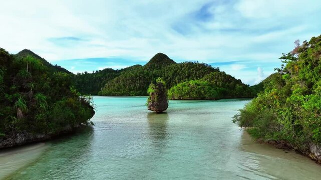Aerial view of beautiful tropical islands with pristine beaches and clear blue lagoons, Raja Ampat Regency, Indonesia.