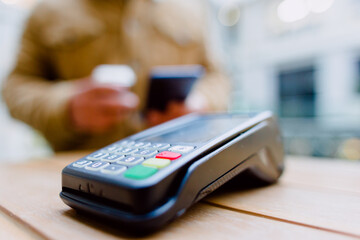 Contactless payment process showing customer using smartphone and credit card near nfc point-of-sale terminal