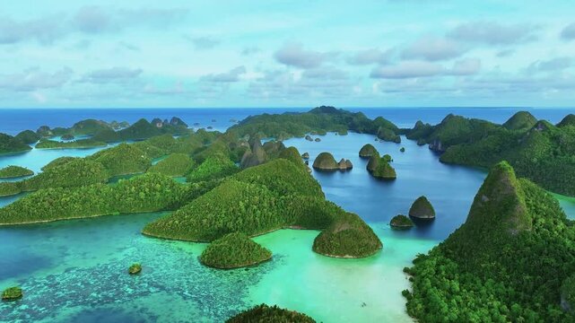 Aerial view of beautiful tropical islands with pristine clear water and lush greenery, Raja Ampat Regency, Indonesia.