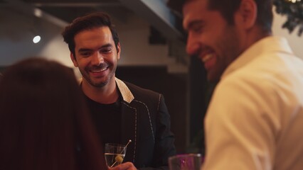 Focusing smart man lively talking with friends while enjoy drinking Martini with olive cocktail at luxurious counter nightclub creating vibrant engaging atmosphere on Friday night meeting. Vinosity.