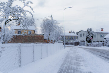 Small town street in winter in Latvia with piles of ice and snow