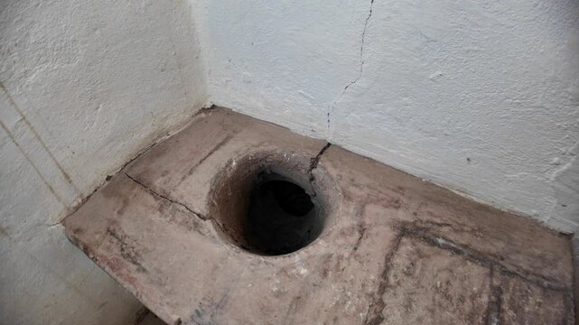 Stone carved toilet seat nestled within Dozza Castle, Italy, showcasing medieval hygiene practices alongside intricate architectural details of this historic fortress