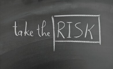 Motivational Text on Chalkboard with the motivational phrase 'Take the Risk' handwritten in chalk, symbolizing inspiration, courage, and decision-making.