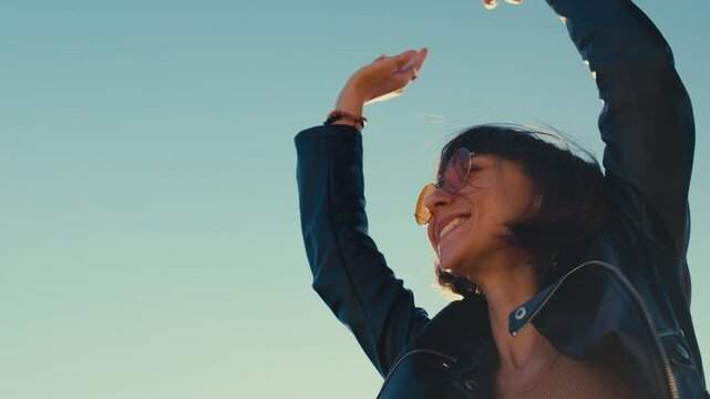 girl at a rock concert, stylish girl in a leather jacket outdoors, rock music, happy woman in sunglasses.