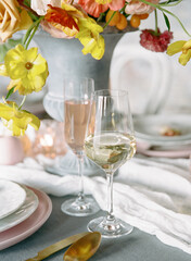 Elegant dining setup with floral centerpiece and sparkling beverages for a festive occasion in a bright environment