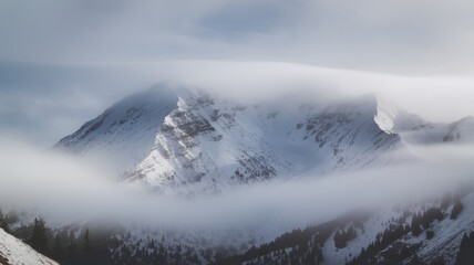 Obraz premium A breathtaking view of majestic snowy mountains enveloped in a soft blanket of mist, creating a serene and mystical winter landscape.