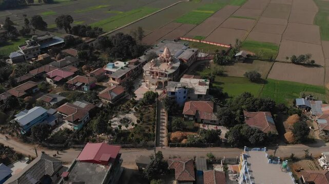 Aerial shot of Radha Krishna Temple in the middle of the Village and big plain fields in the background, Terai Nepal