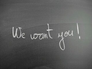 Obraz premium Handwritten message on blackboard displaying 'We want you' in white chalk for motivation and recruitment