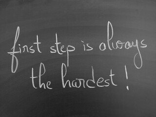 Inspirational handwritten quote on a chalkboard highlighting "the first step is always the hardest" as a motivational theme