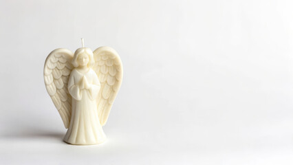 Fototapeta premium Symbolic death reflection with white angel-shaped candle on white background minimalist setup for serenity