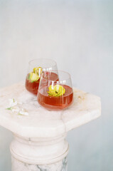 Refreshing beverages served in elegant glasses on a marble table in a serene setting during daylight hours