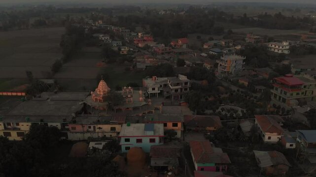 Aerial shot of Radha Krishna Temple in the middle of the Village and big plain fields in the background, Terai Nepal