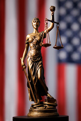 Lady Justice figure holding scales in front of American flag representing law and order