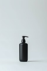 Obraz premium Minimalist black matte cosmetic pump bottle isolated on white background, modern packaging design for skincare and beauty products.