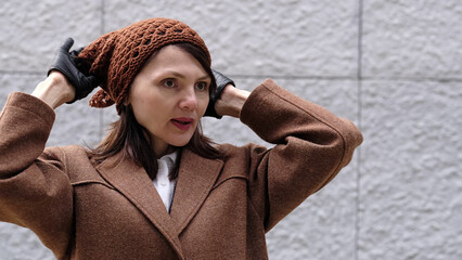 A portrait of a woman outdoors, her knitted hat and cozy coat emphasizing seasonal warmth.