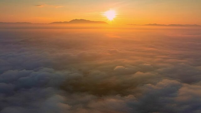 Aerial view of The huge rain clouds at sunset are beautiful colorful with lightning flashing. The orange sunlight shines through the clouds, looking terrifying.