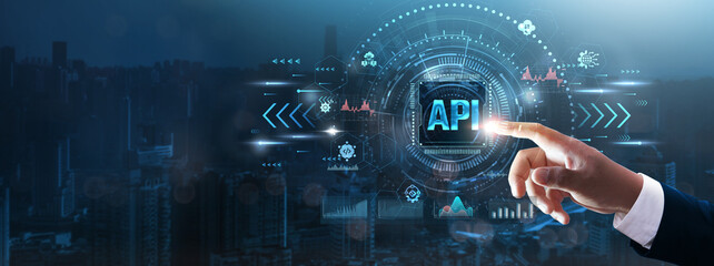 API: Businessman’s hand touching futuristic technological interface, application programming interface, data integration, system connectivity, and business automation concept.
