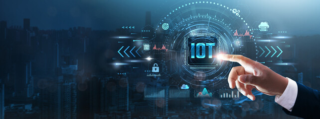IOT: Businessman’s hand touching futuristic technological interface, smart devices, connectivity, data exchange, and intelligent business solutions and technology concept.