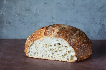 Fresh homemade sourdough bread with whole grain flour on a on a gray-brown background. Healthy food.