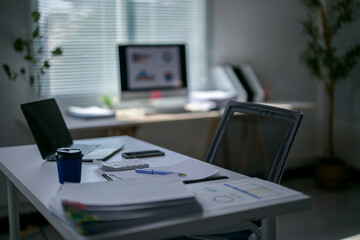 A desk with a laptop, a cell phone, a cup of coffee, a keyboard, a mouse