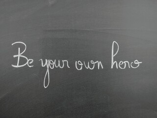 Obraz premium Chalkboard with the inspirational handwritten message 'Be your own hero' emphasizing self-motivation and inspiration