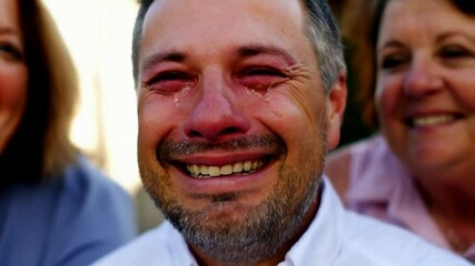 Man Sheds Tears of Joy While Embracing Family After Achieving Personal Milestone in Slow Motion Close-Up