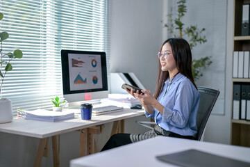 A woman is sitting at a desk with a computer monitor