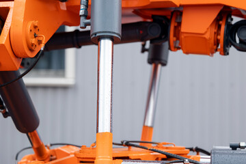 Pneumatic hydraulic piston for industry machinery technology. Concept chrome plated cylinder shaft of yellow bulldozers, tractors, excavators for lifting