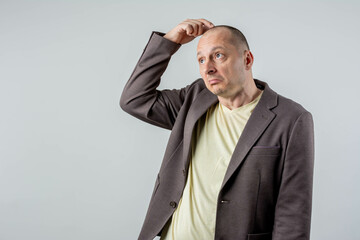 mature adult man thinking, feeling doubtful and confused, with different options, wondering which decision to make