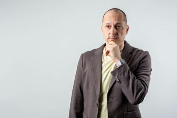 New project. Front view of business man and formal wear and touching his chin while standing isolated.