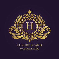 Gold Letter 'H' Logo with Ornamental Patterns and Floral Motifs on Purple  
