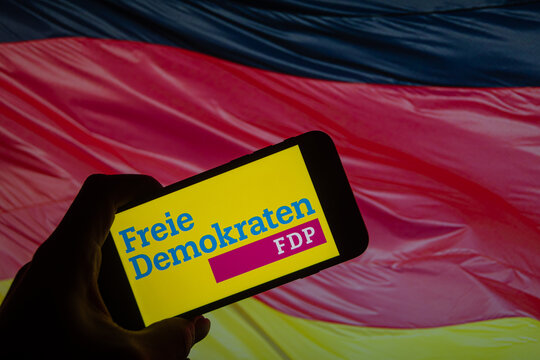 Rheinbach, Germany  26 January 2025,  The logo of the German party "FDP" on the display of a smartphone in front of a German flag (focus on the logo)