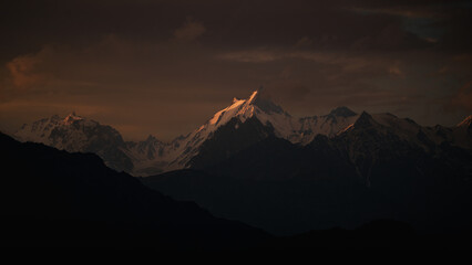 Sunset illuminating snow capped peaks in the karakorum range, pakistan, creating a dramatic...