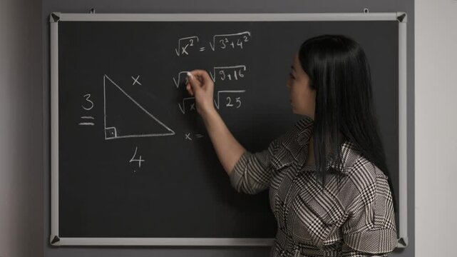 The teacher writes various mathematical formulas on a blackboard and gives the lesson. Teacher writes on blackboard.