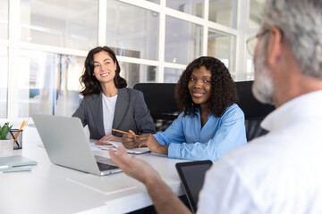 Bearded businessman in wheelchair leading group of professionals in office