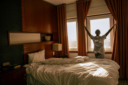 Black woman opening the curtains
