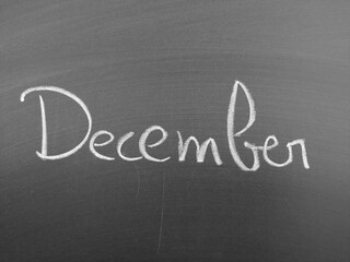 Obraz premium Handwritten Script of the Word December on Chalkboard in Stylish Cursive Letters