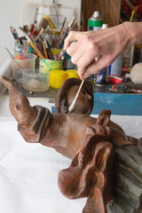 The restoration of statue of saint - detail of hands at work