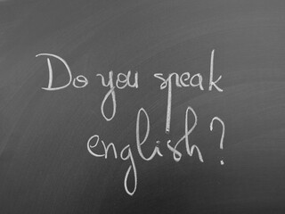 Handwritten text on a chalkboard asking the question 'Do you speak English?'
